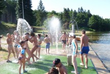 La plage du lac de Coucouron est dotée d'un espace de jeux pour les enfants : jets d'eau, toboggan...